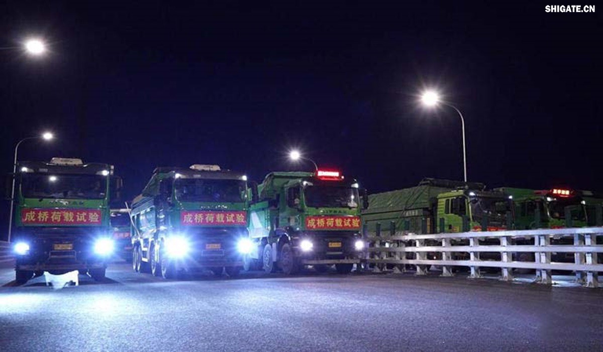 6月16日22時，世界最大跨度斜拉橋——常泰長江大橋燈火通明，車聲轟鳴，一場通車前的“極限挑戰(zhàn)”正緊張進(jìn)行。30輛總重達(dá)1200噸的四軸加載車，分批列隊駛上橋面預(yù)先劃定的停靠點，并由提前布置在橋梁各關(guān)鍵部位的869個傳感器開展實時監(jiān)測，采集測試數(shù)據(jù)。由此，大橋跨江公鐵合建段主橋橋梁荷載試驗全面啟動。    AA1GQ79M.jpg    這次荷載試驗覆蓋范圍具體包括1座主跨1208米斜拉橋、2座主跨388米鋼桁拱專用航道橋、1座非通航道孔橋以及南北兩座引橋，共設(shè)計119個靜載工況和111個動載工況。其中，最大對稱靜力加載工況將動用110輛四軸加載車，總重達(dá)4400噸。試驗將持續(xù)一周，分五個階段進(jìn)行。試驗首日在錄安洲非通航孔橋和常州側(cè)公鐵合建段引橋?qū)嵤? 常泰長江大橋是連通常州與泰興的跨江通道，是長江上首座集高速公路、城際鐵路和普通公路三種功能于一體的雙層復(fù)合型橋梁，計劃于今年年內(nèi)基本建成。它的上層為雙向六車道高速公路，下層為雙線城際鐵路和普通公路。如此復(fù)雜的結(jié)構(gòu)，如何確保它在未來百年服役中安全可靠？答案就藏在荷載試驗中。    AA1GQduQ.jpg    荷載試驗堪稱橋梁通車前的“綜合大考”，是確保橋梁安全運營的“體檢報告”。江蘇省交通工程建設(shè)局常泰長江大橋建設(shè)指揮部現(xiàn)場常務(wù)副指揮長夏鵬飛介紹，“荷載試驗是檢測橋梁結(jié)構(gòu)安全和承載能力的重要手段，通過科學(xué)的加載測試和數(shù)據(jù)采集分析，驗證實際成橋狀態(tài)與理論設(shè)計的鍥合度，確保常泰長江大橋運營安全。”考慮到大橋主體采用鋼結(jié)構(gòu)和鋼-混凝土組合結(jié)構(gòu)，為最大限度減少晝夜溫差對測試數(shù)據(jù)的影響，所有試驗均安排在夜間實施。  通過一系列科學(xué)嚴(yán)謹(jǐn)?shù)暮奢d測試，這座世界級多功能大橋的實際性能將得到充分檢驗，為常泰長江大橋后續(xù)安全通車運營提供至關(guān)重要的數(shù)據(jù)支撐。